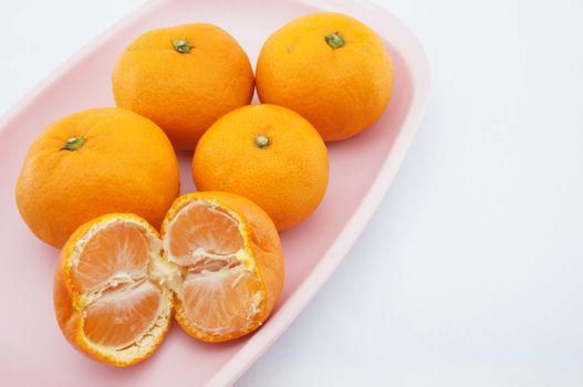 Sour orange have not seeds placed on pink tray with white background.