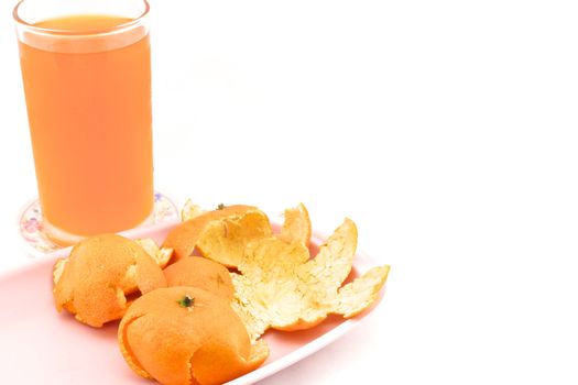 Cold orange juice in glass placed on coasters and orange peel with white background.