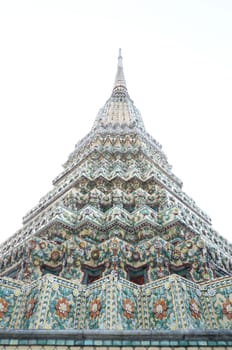 Pagoda in Wat Pho decorated with small pieces of tiles of different colors and flower motifs.