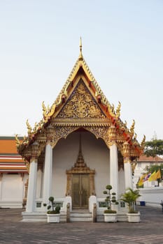 Church in Wat Pho decorated in gold and red. Orange and green roofs