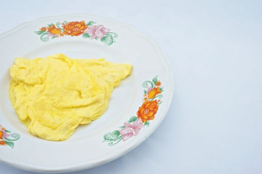 Omelette made a triangle placed on the plate with white background.