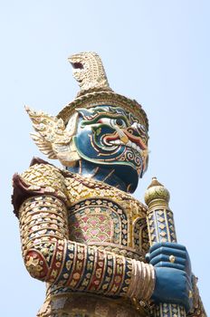 Large giant statue holding a baton in a standing Buddha.