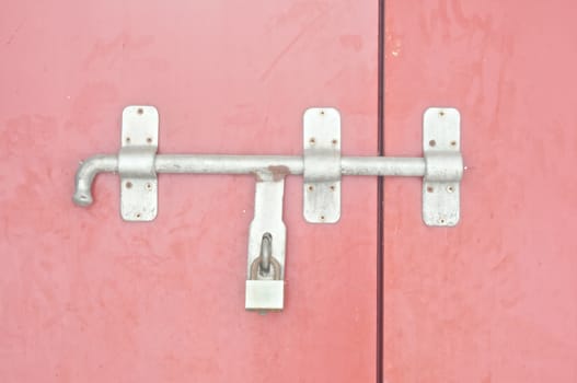 Red antique door was locked with a old silver key.