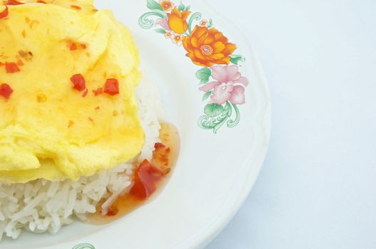 Omelette made a triangle put on rice placed on the plate with white background.