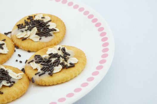 Crackers with oat, chocolate and  sweetened condensed milk placed on dish.