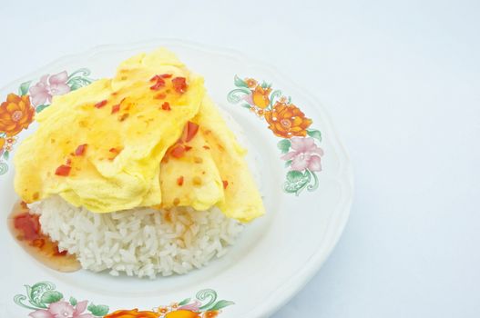 Omelette made a triangle put on rice placed on the plate with white background.