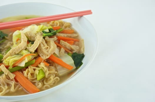 Egg noodle and clear soup vegetarian for health. It include vegan protein dry, carrot, kale and cabbage on white background.