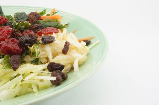 Healthy Salad consists apple carrots mango raisins and tomatoes.