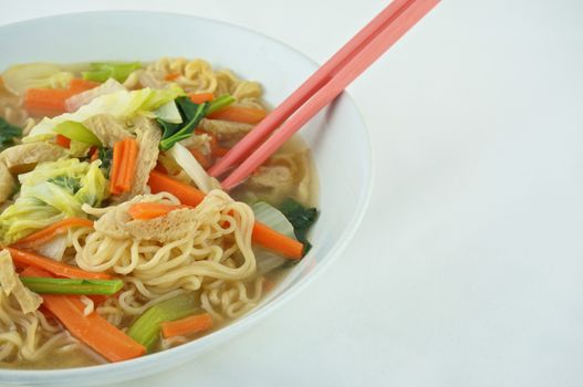 Egg noodle and clear soup vegetarian for health. It include vegan protein dry, carrot, kale and cabbage on white background.