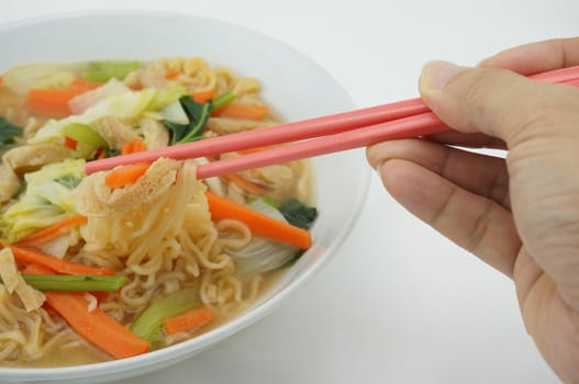 Egg noodle and clear soup vegetarian for health. It include vegan protein dry, carrot, kale and cabbage on white background.