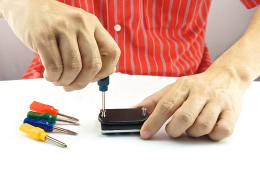 Man using screwdriver with screw for minor repair with white background.