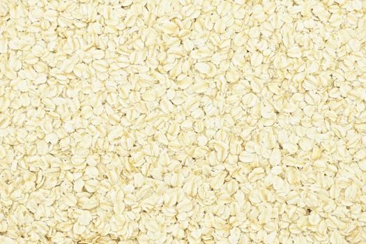 Porridge oats or oatmeal for breakfast put as abstract background texture.