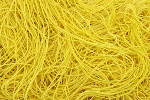 Thin noodle or long life noodle is yellow noodle  overlap as background.