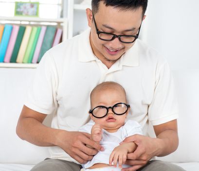 Asian family lifestyle at home. Father and baby with nerd glasses.