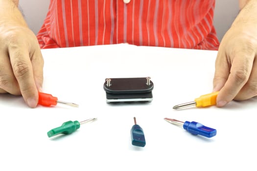 Man using screwdriver with screw for minor repair with white background.