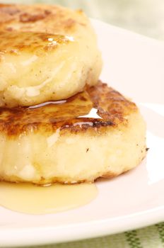 Delicious homemade cheese pancakes with honey closeup