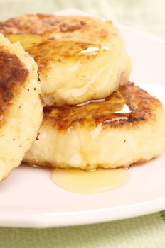 Delicious homemade cheese pancakes with honey closeup