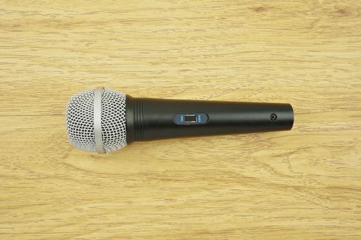 Black and silver microphone set switch on place with wood background.