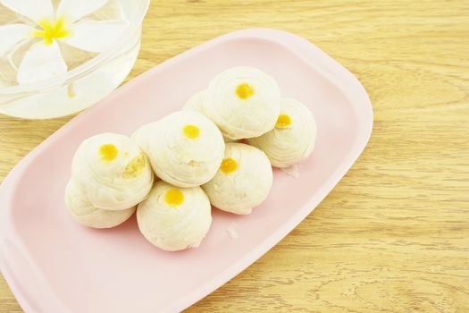 Chinese pastry place on a pink tray with wood background.