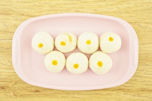 Chinese pastry place on a pink tray with wood background.