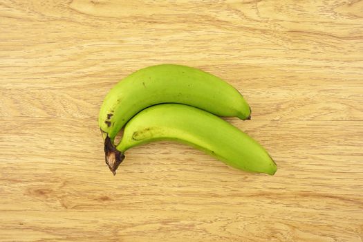 Green cavendish banana put on wood background.