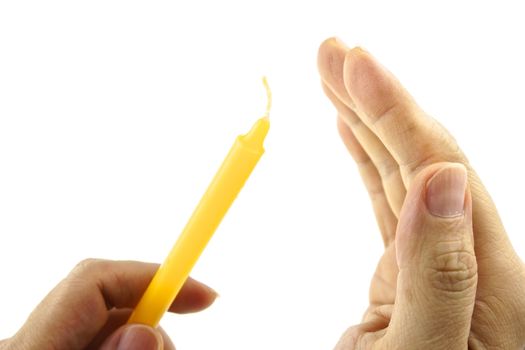 Hand hold yellow candle for lit and shield from wind isolated with white background.