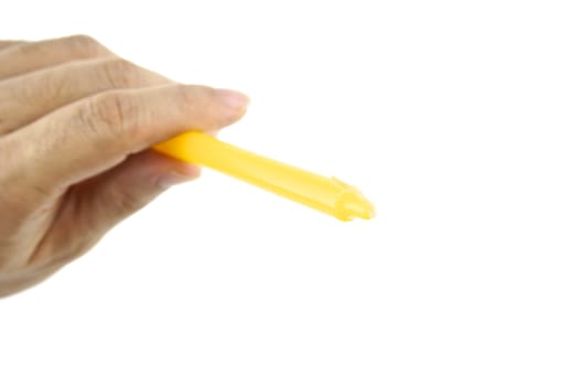 Hand hold yellow candle for lit from top left isolated with white background.