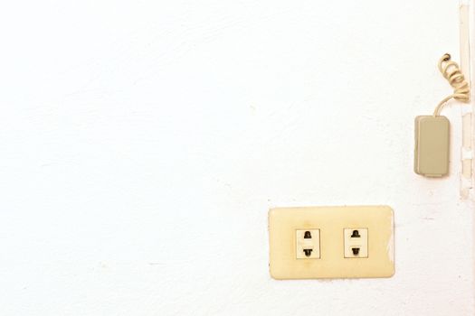 Old plug and phone connect box on wall of room.