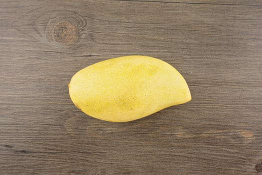 Big yellow mango or Mangifera indica put on wood background.