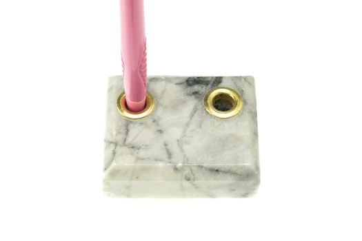 Pink pen in pen holder made from marble isolated with white background.