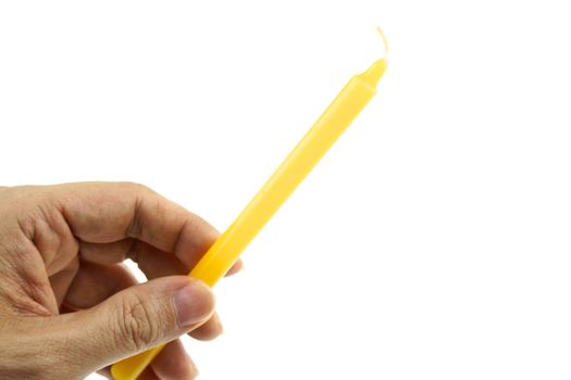 Hand hold yellow candle for lit from bottom left isolated with white background.