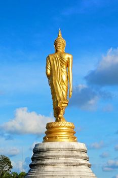 Behind of golden buddha statue with blue sky in Thailand.