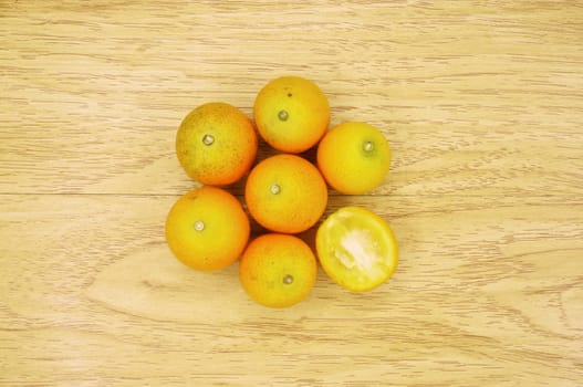 Small orange form china and sliced place on wood background.