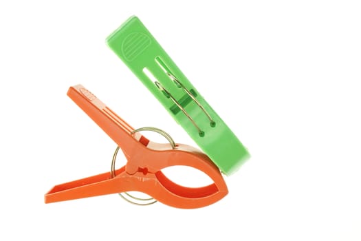 Big green and orange clothes Pegs isolated with white background.