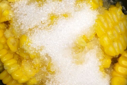 Closeup shear corn with sugar and salt in black bowl.