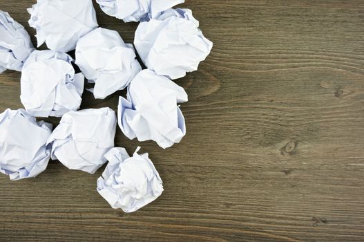 Group of white paper ball place on left with black wood background.