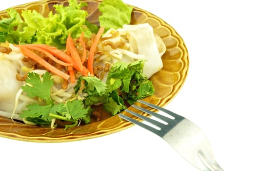 Eating wide rice noodle roll with fork isolated on white background.