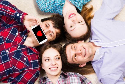 four young people are together, the young man pressed his lips to the phone