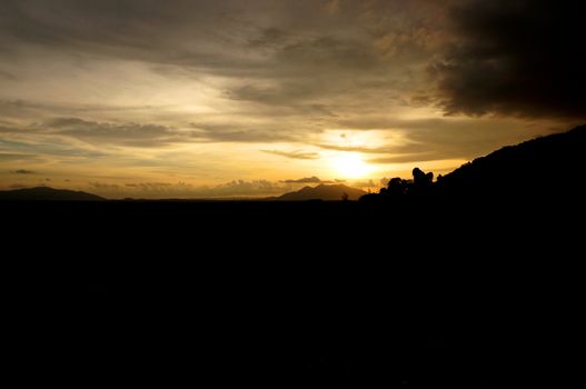 Sunset behind of mountain with gold sky silhouette in Thailand.