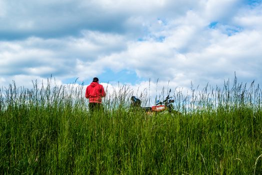 STUTTGART, GERMANY - MAY 17, 2014: A man with his moped is having a break in the fields around the airport in great weather on May, 17, 2014 in Stuttgart, Germany.