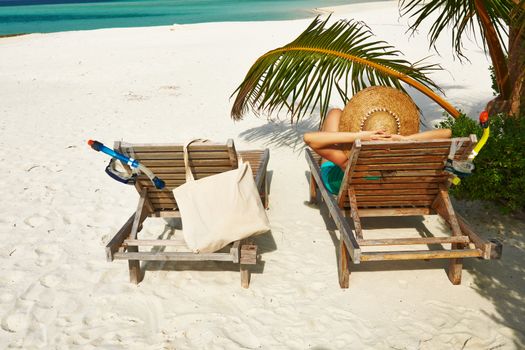 Woman at beautiful beach with chaise-lounges