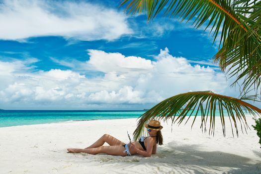 Young woman in hat with tablet pc at the beach