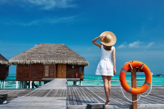 Woman on a tropical beach jetty at Maldives