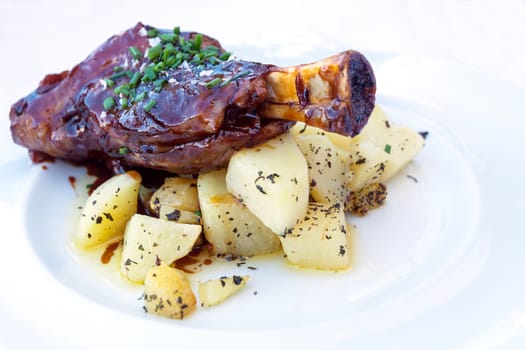 Braised lamb shank with potatoes and onion