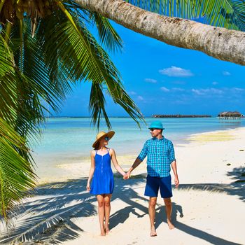 Couple in blue clothes on a tropical beach at Maldives