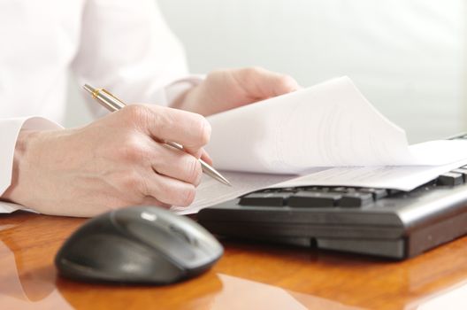 Hands with a document on a computer keyboard