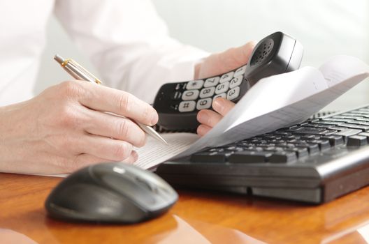 Hands with a handset on a computer keyboard