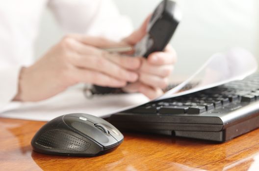 Hands with a handset on a computer keyboard