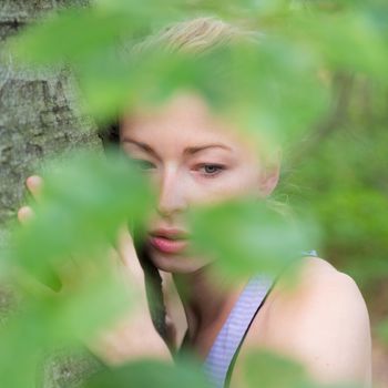 Relaxed young lady embracing a tree receiving life energy from the nature.