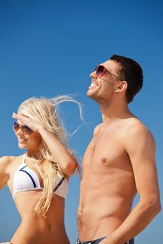 picture of happy couple in sunglasses on the beach (focus on man)